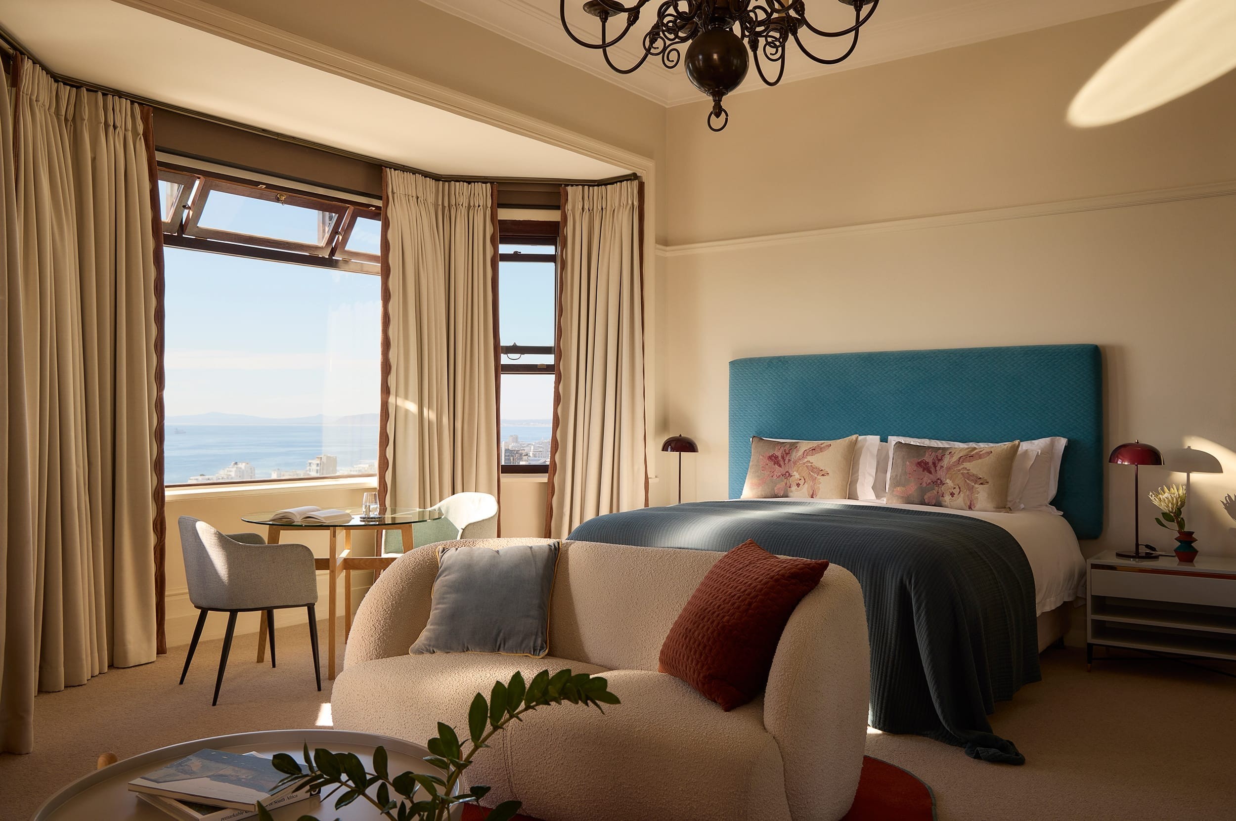 The bed framed by soft natural light in the Deluxe House Room