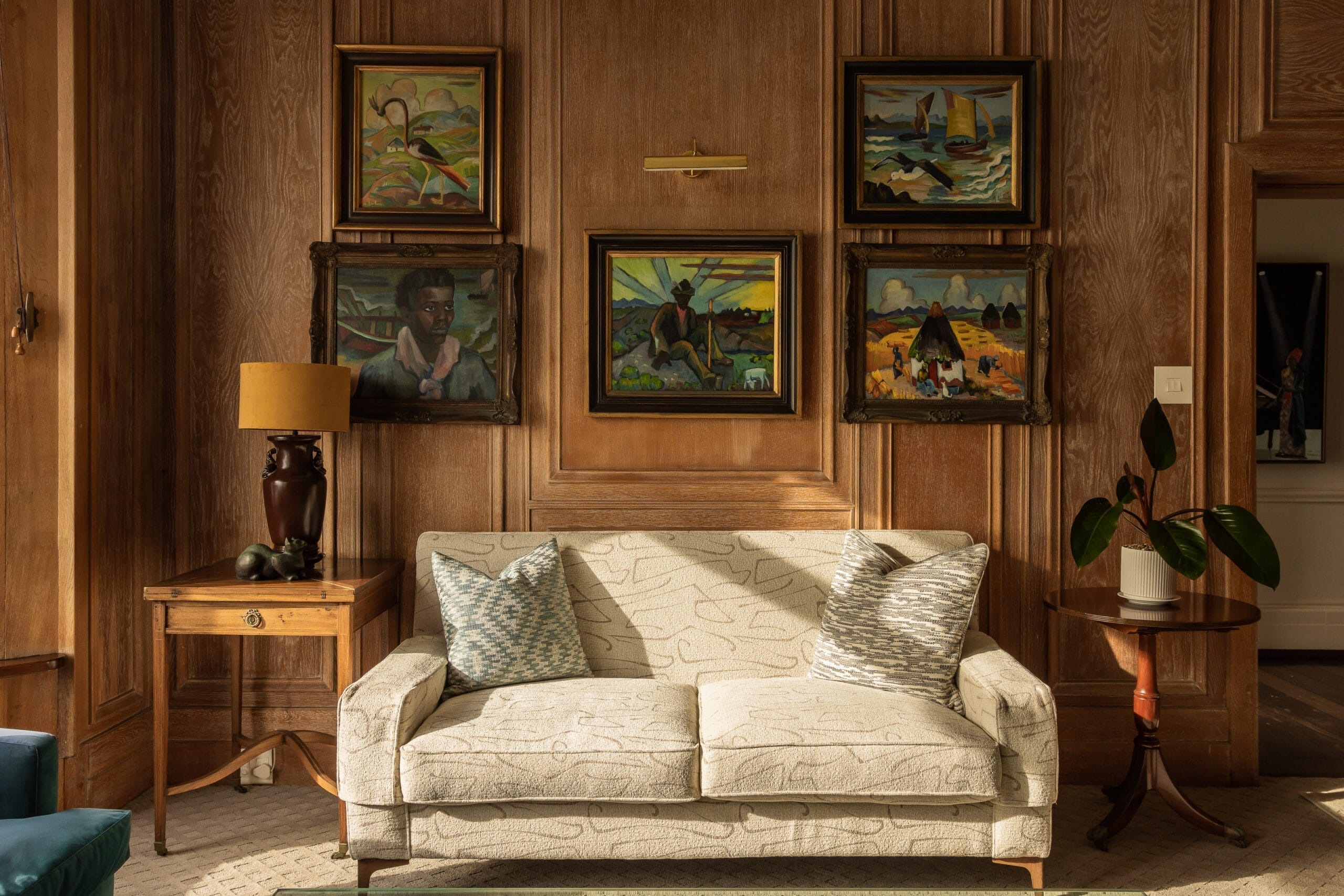 A wood-panelled sitting room hung with South African paintings
