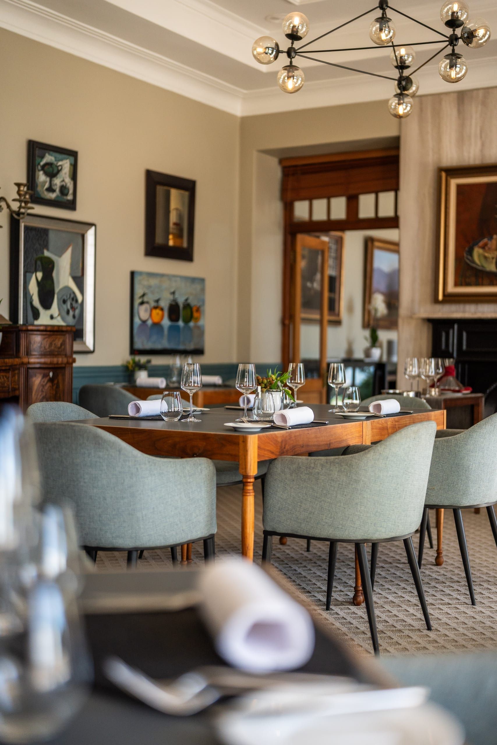 The OneEighty dining room with a set table, ocean light and original art