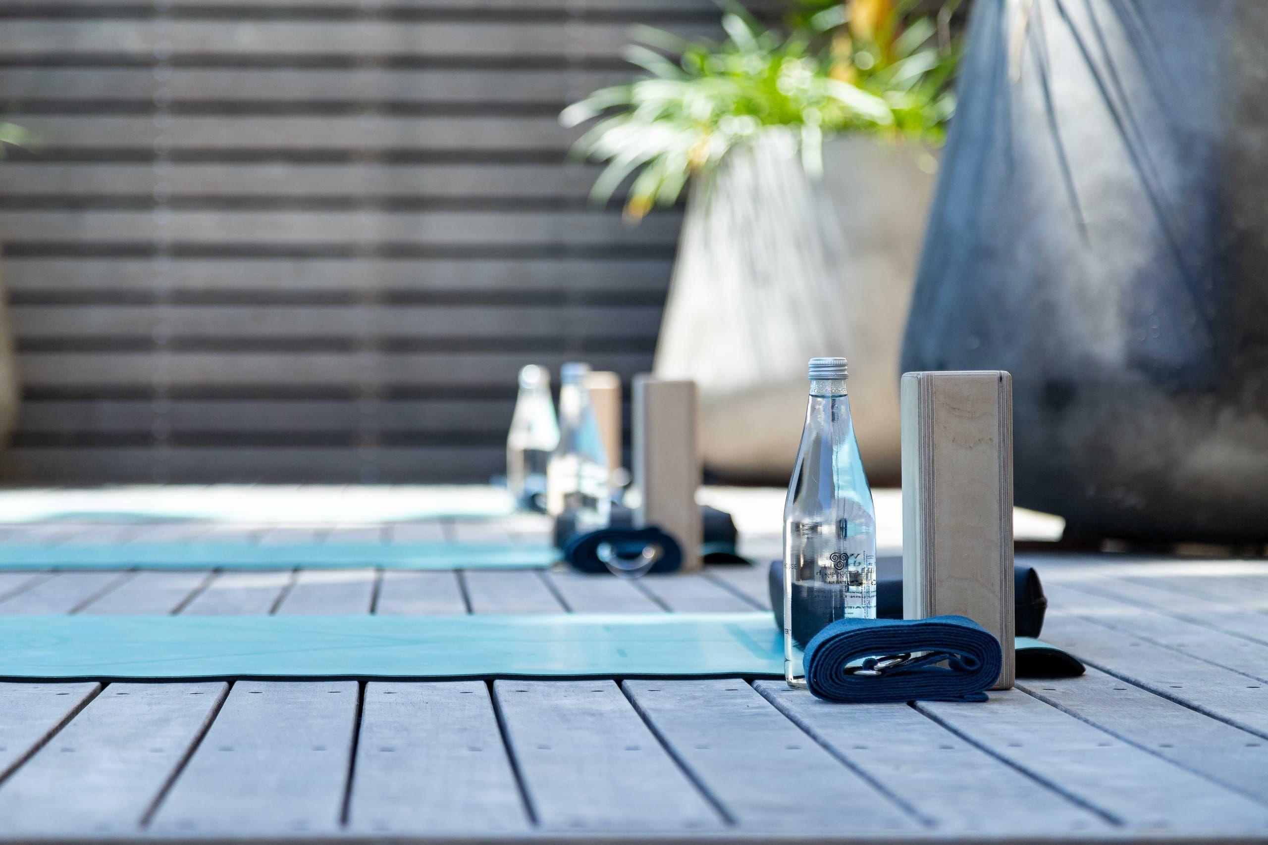 A yoga mat and still water set out on the wellness deck