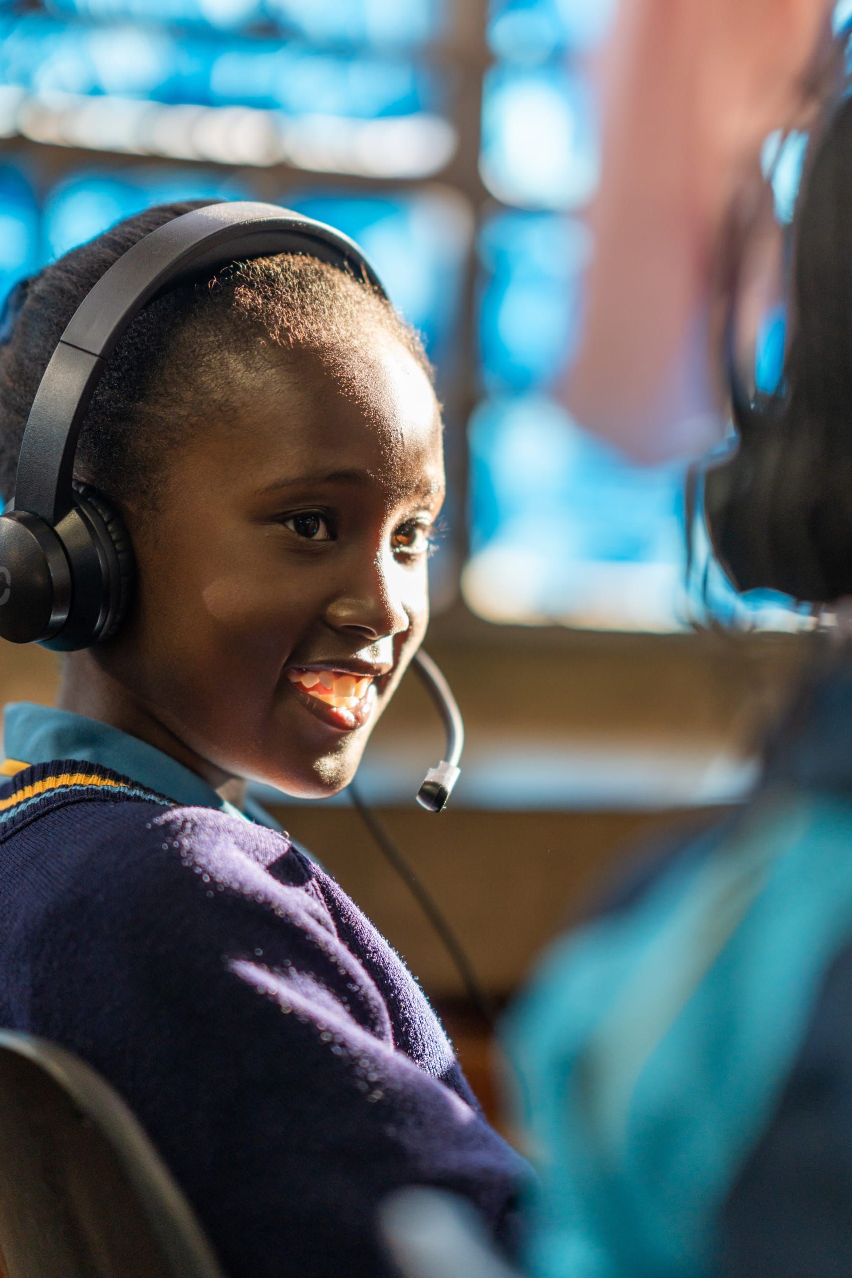 A young learner wearing headphones during a Click Learning digital literacy session