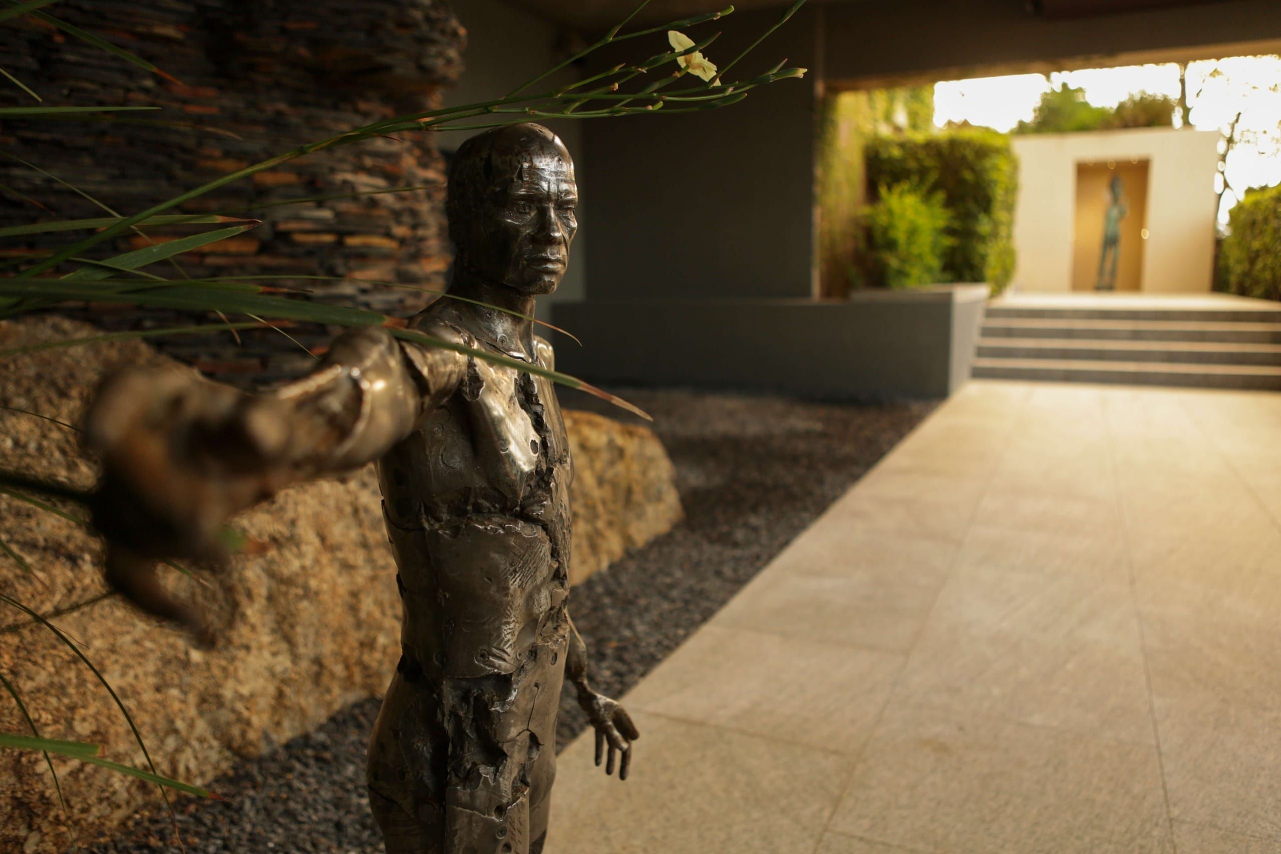 A bronze figure sculpture in the garden at Ellerman House
