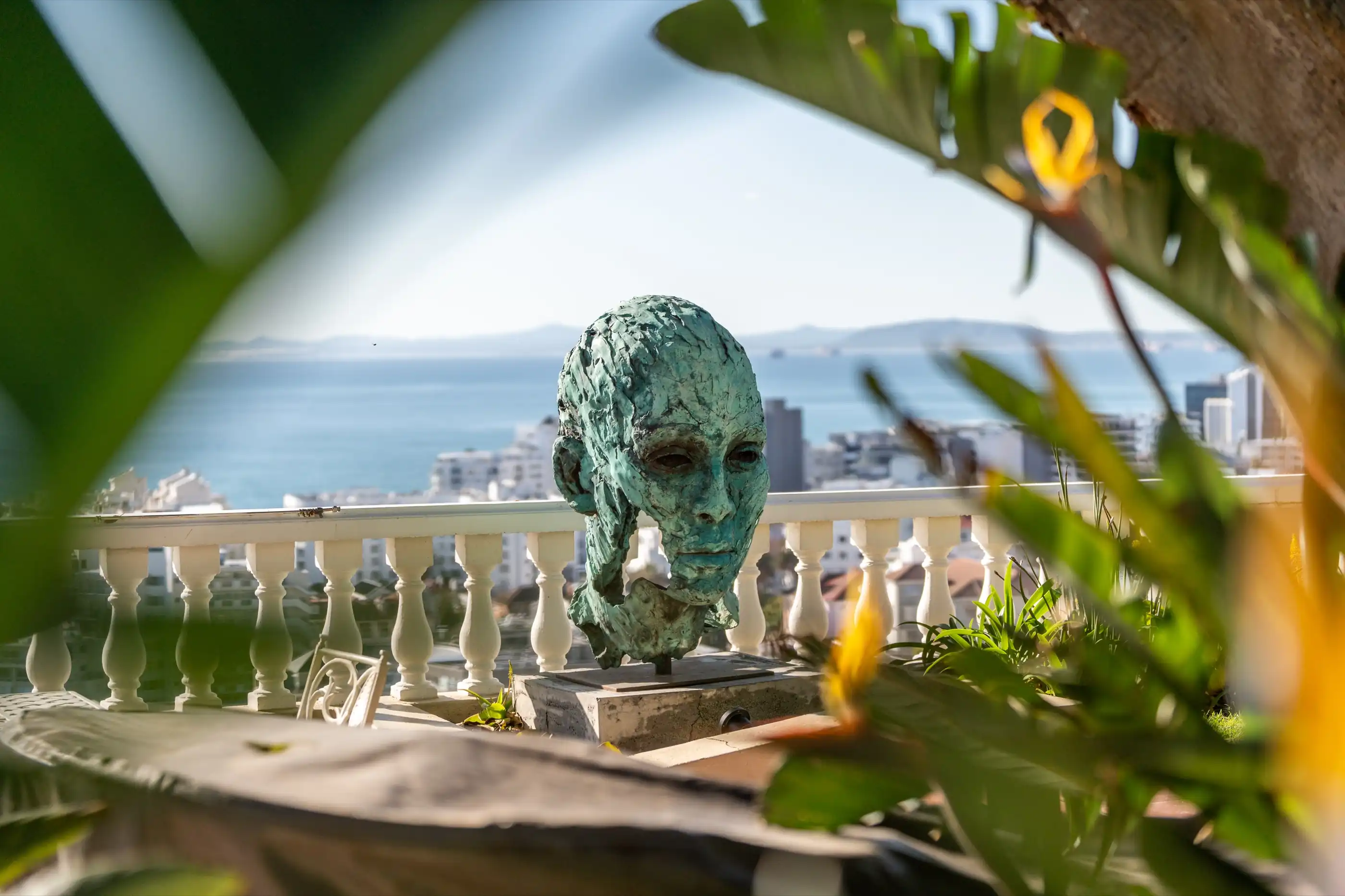 A bronze head sculpture on the terrace balustrade above Bantry Bay
