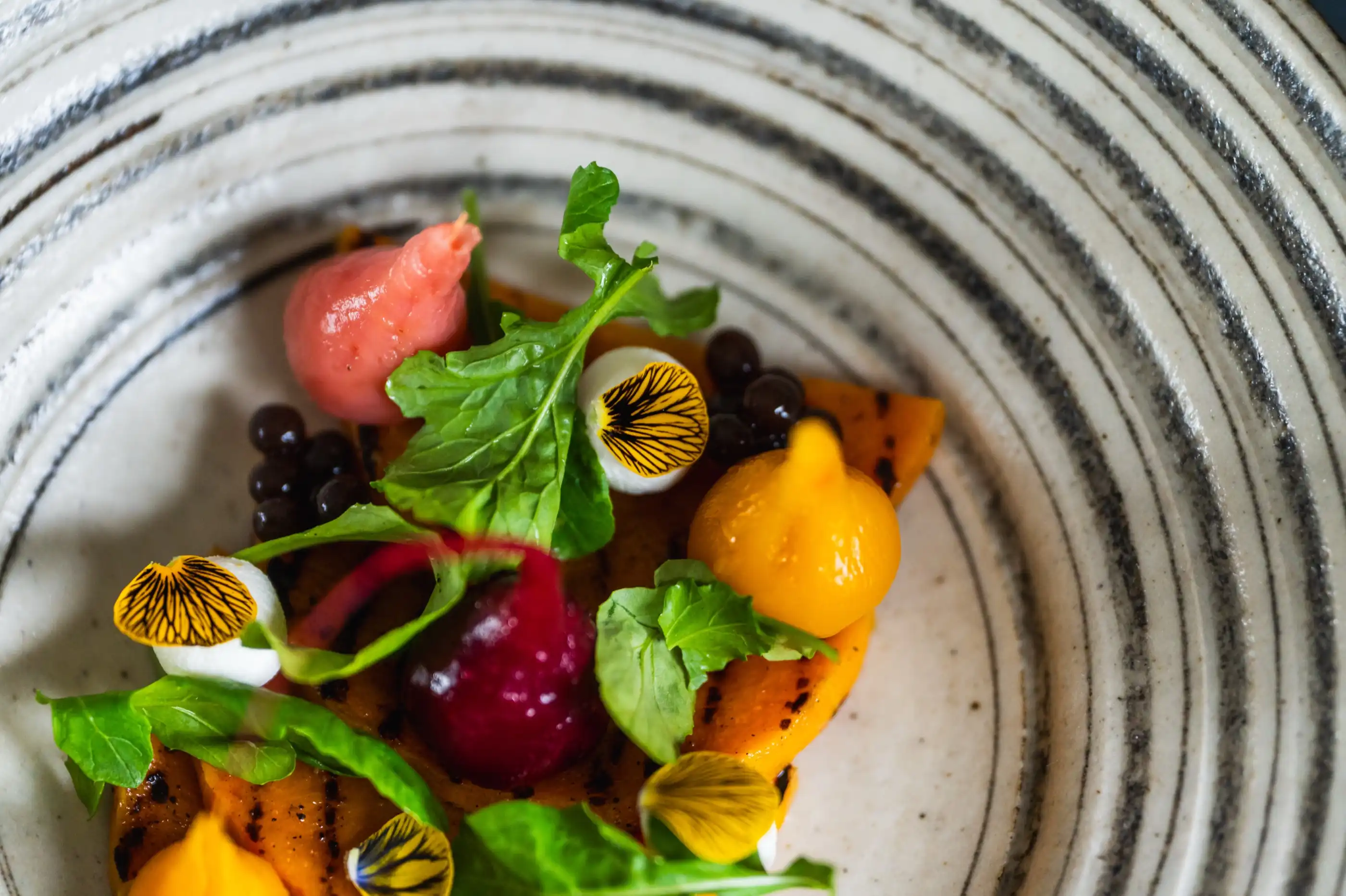 A beetroot salad plated with garden leaves and flowers