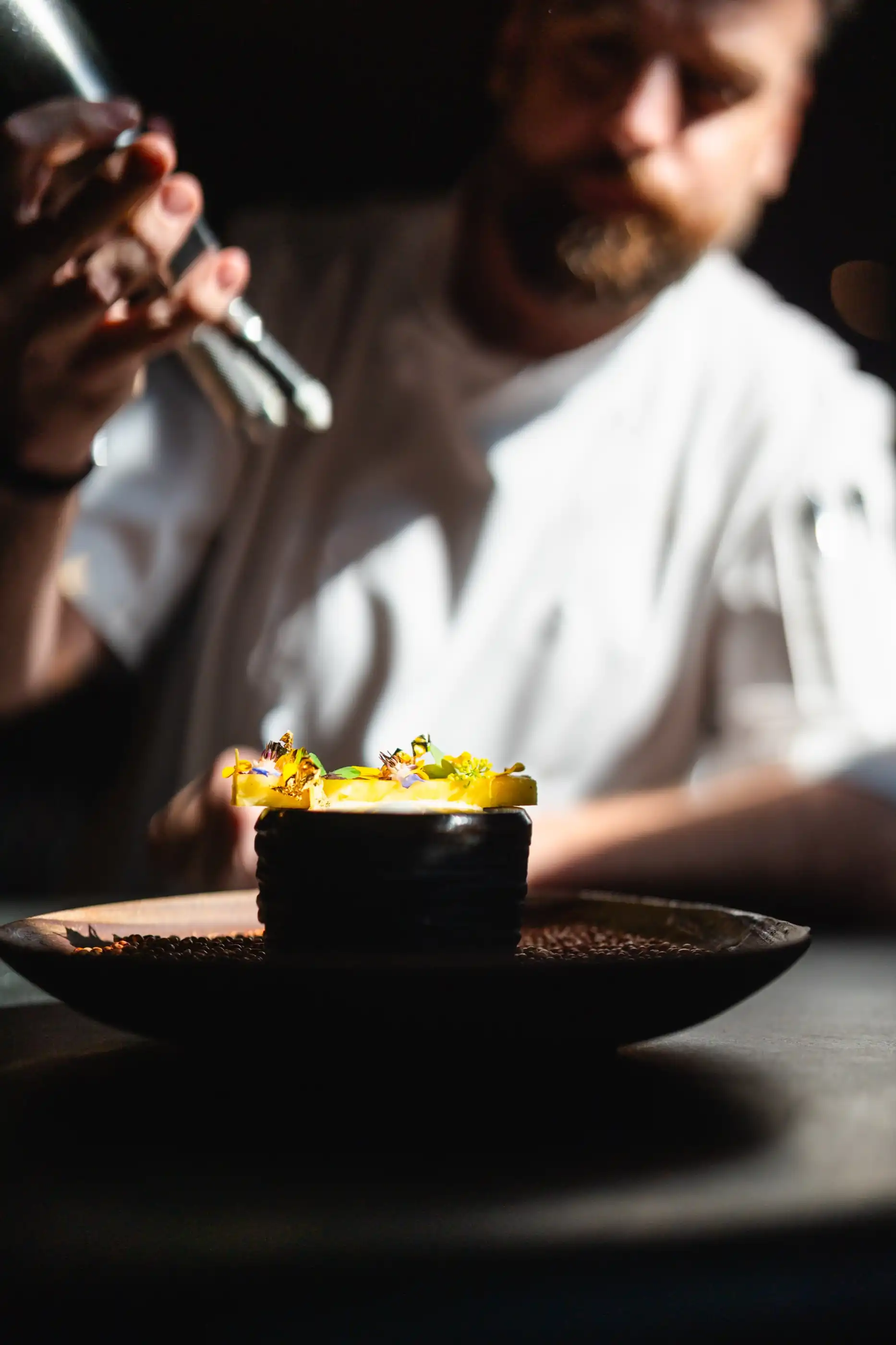 The chef seasoning a course by hand before service