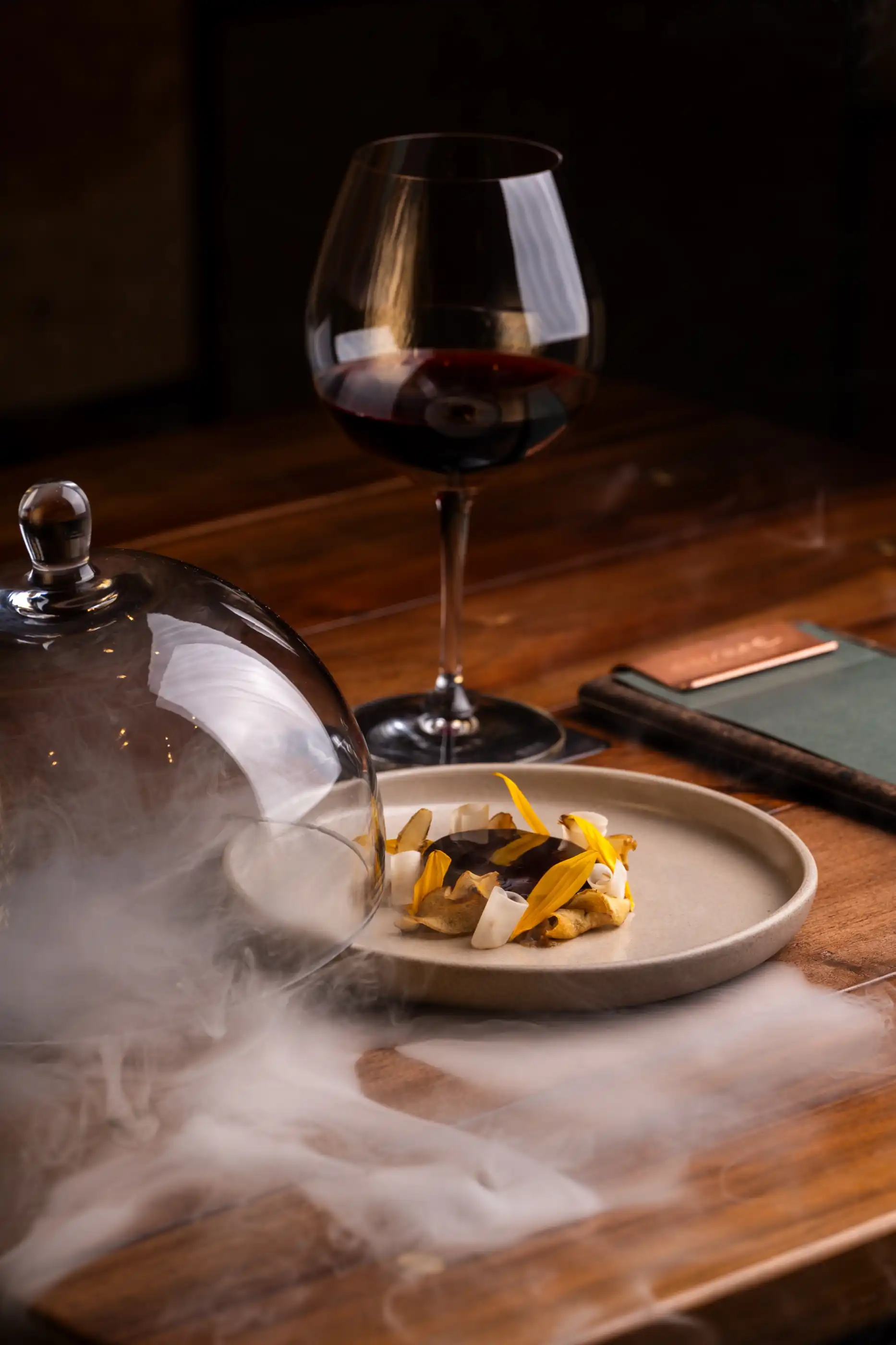 A dessert revealed in a drift of smoke at the table