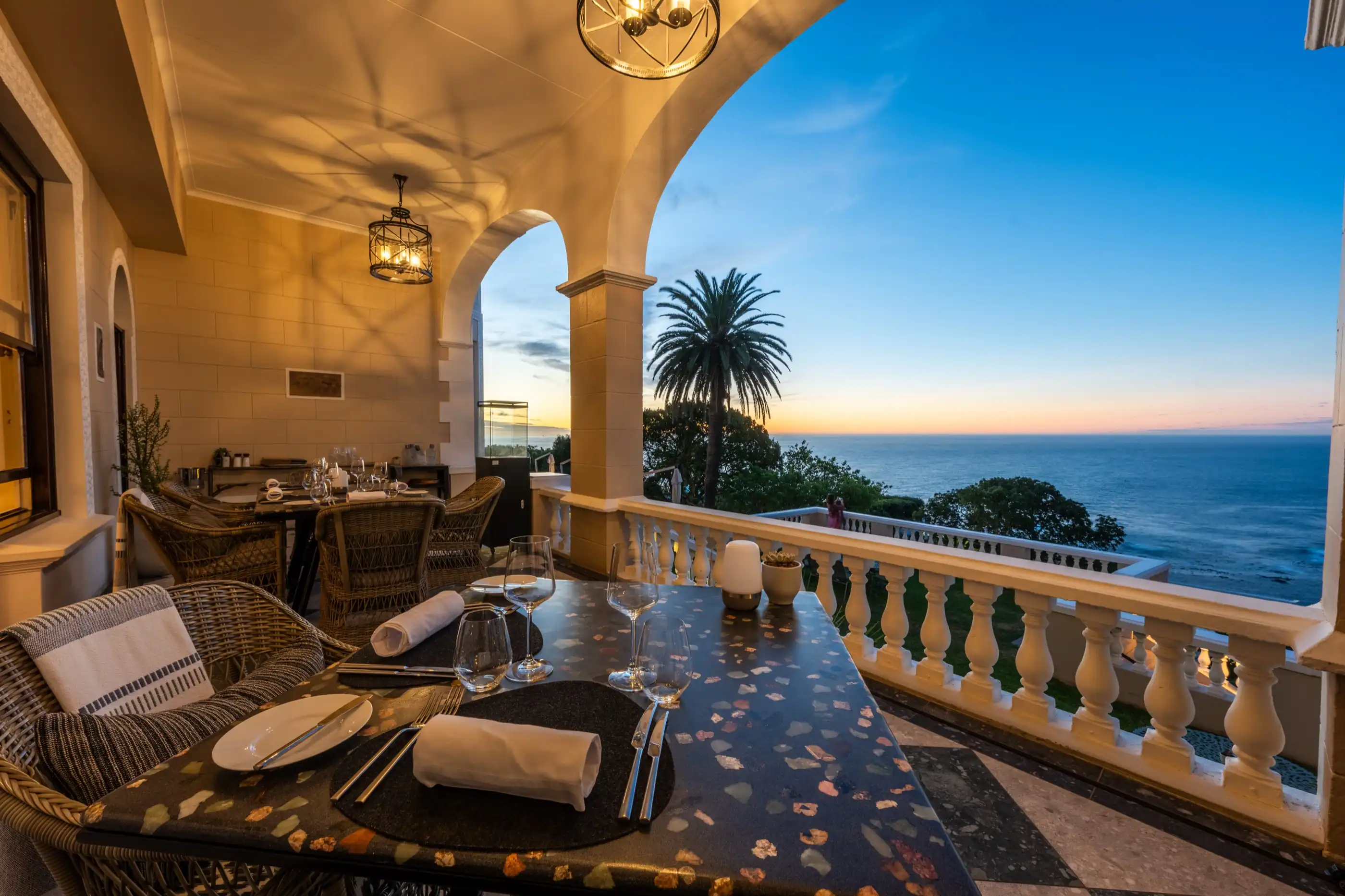 A table set on the terrace as the sun drops into the Atlantic