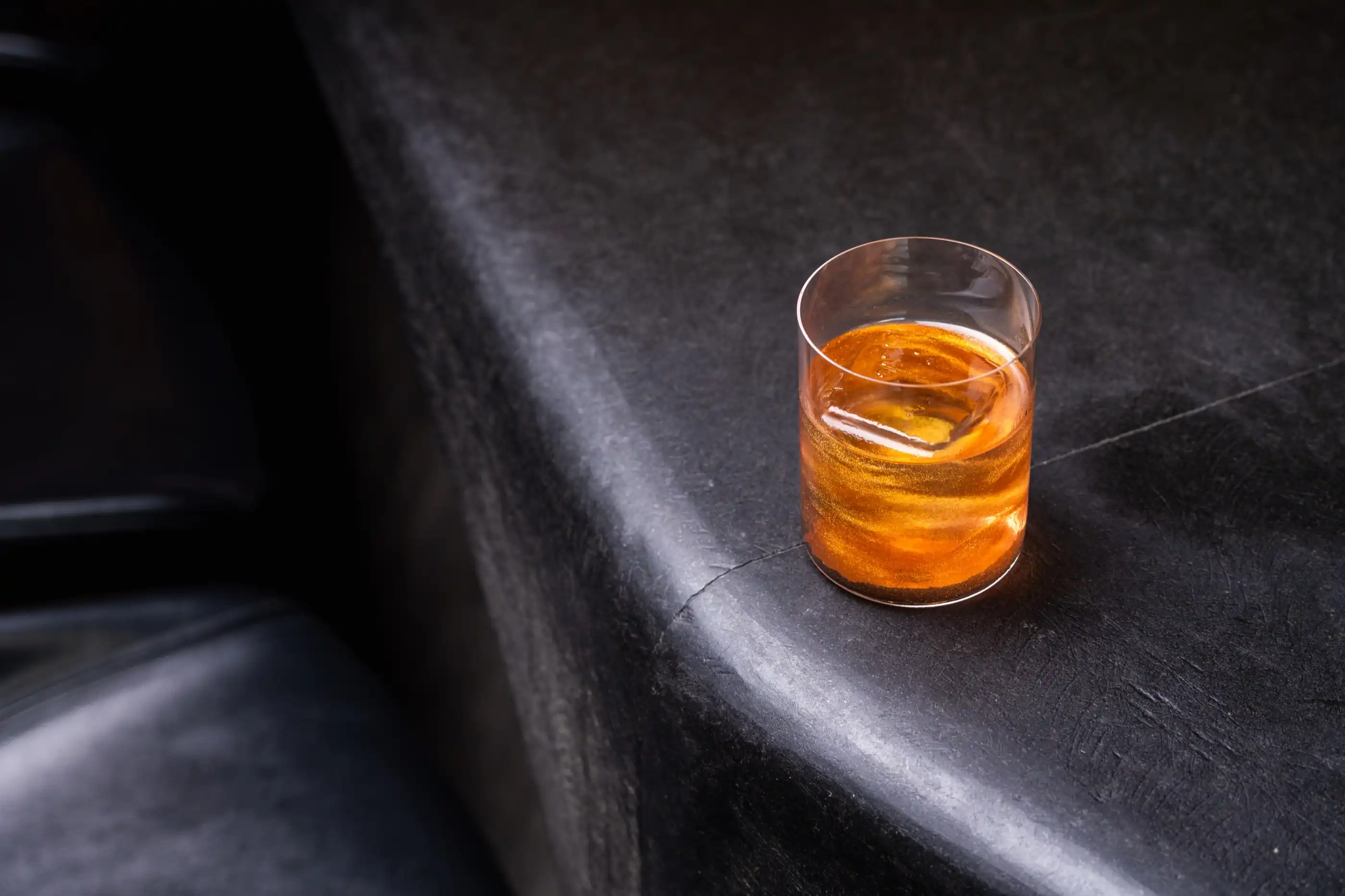 A whisky poured over ice at the bar