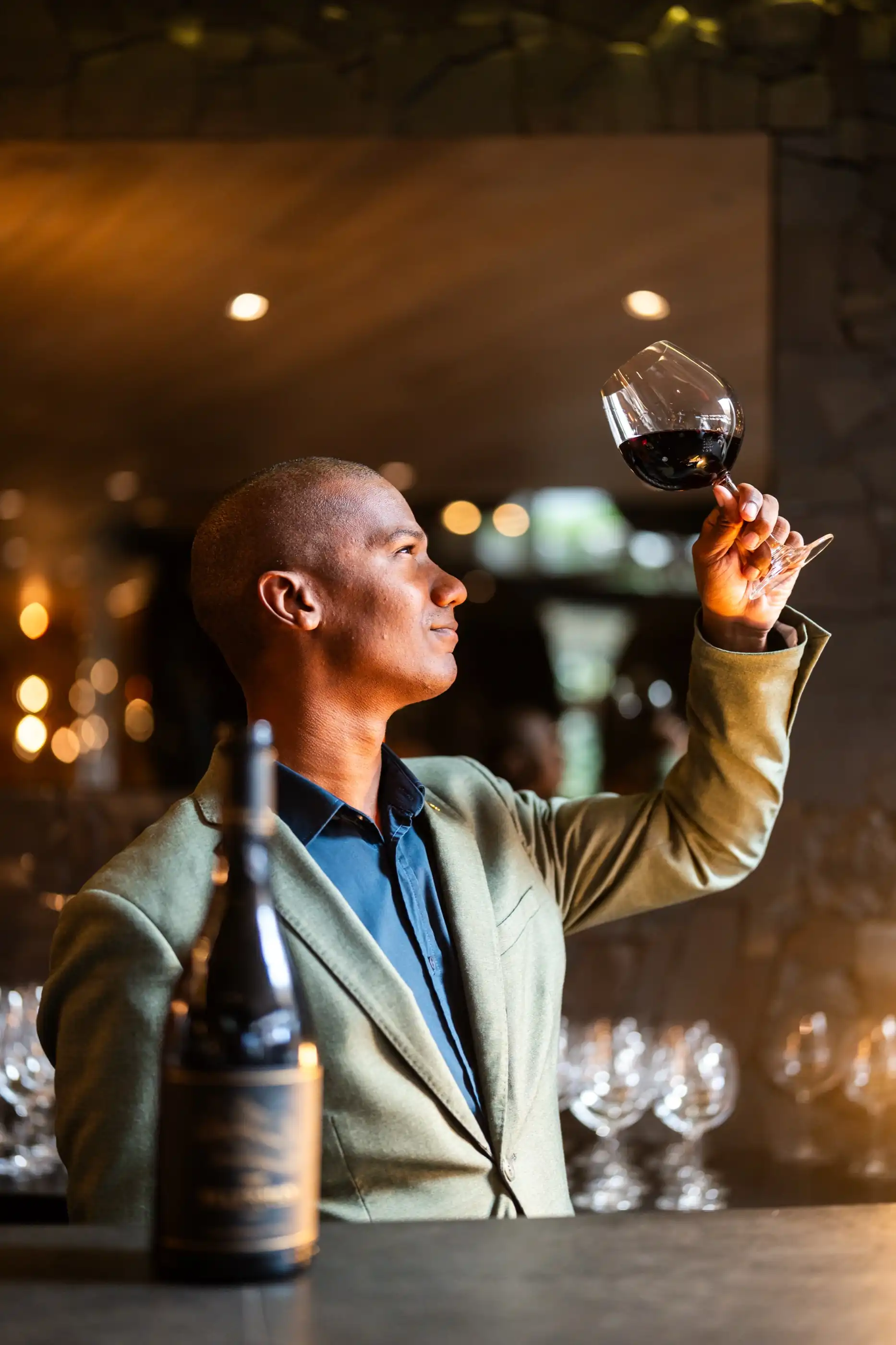 A glass of red wine held during a tasting in the wine gallery