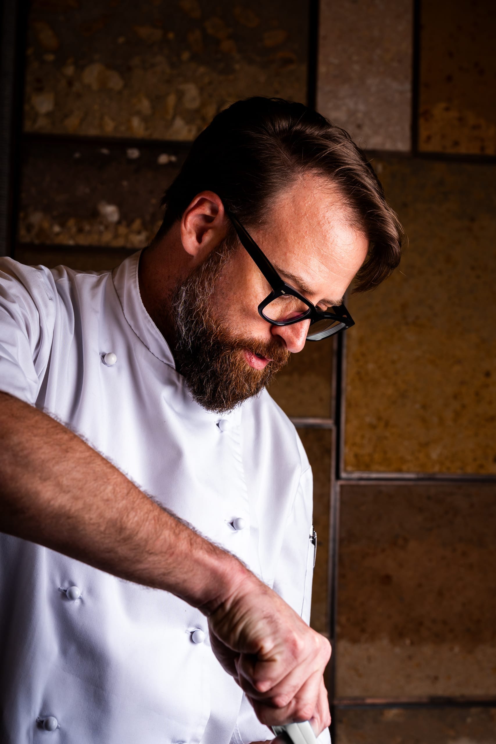 A chef plating a course in the kitchen at Ellerman House