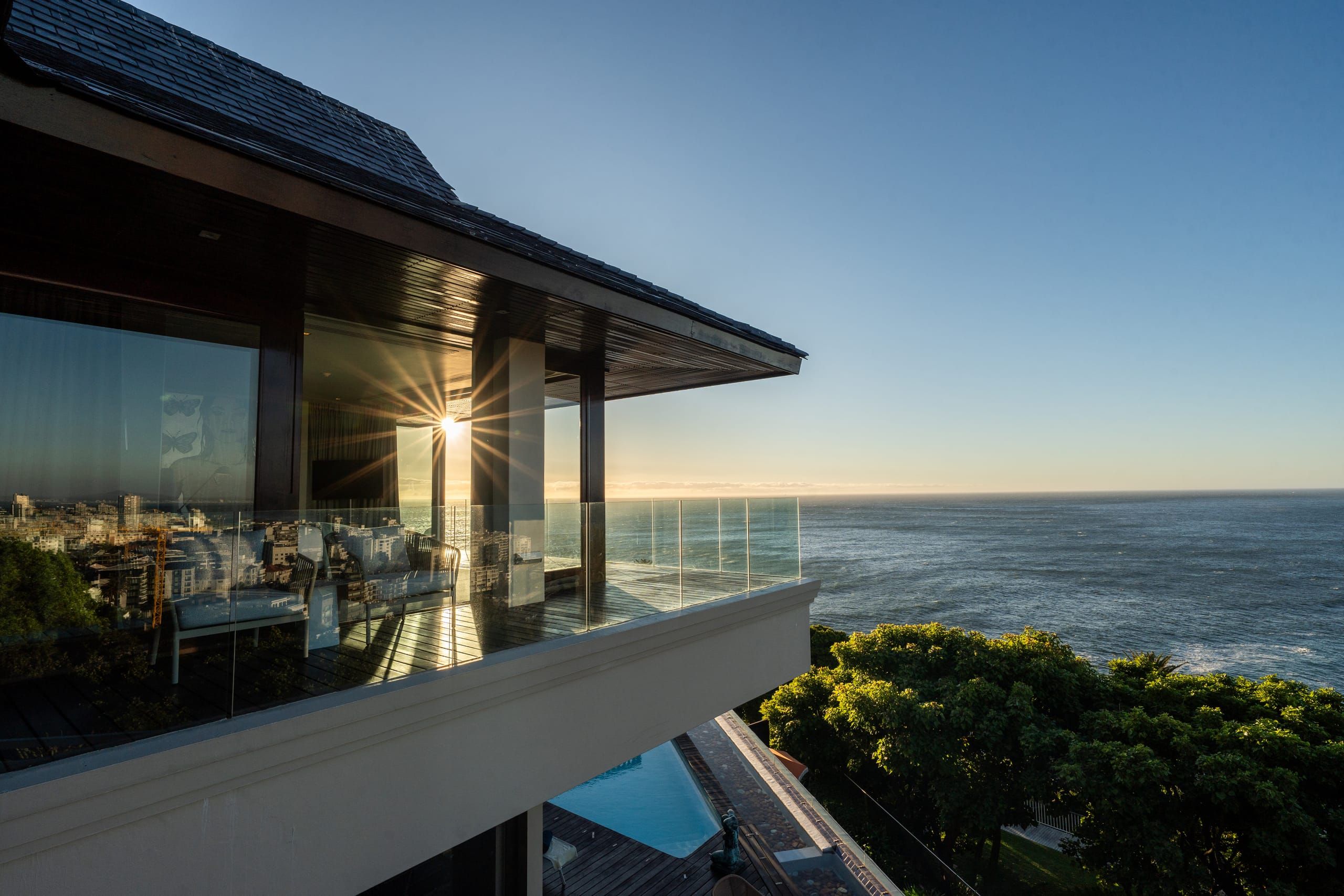 Ellerman House at dusk, its terraces and pool glowing above the Atlantic