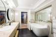 Bathroom with long counter and bath with mirror above it